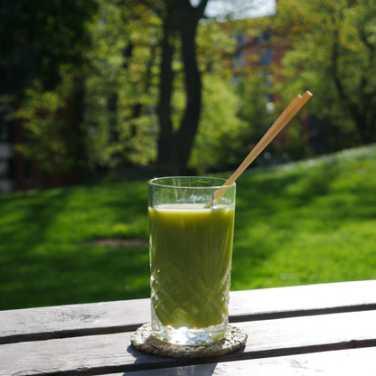 wheat drinking straw in a drink, a crystal glass containing a green juice